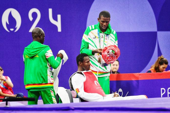 Para taekwondo fighter Idrissa Keita sitting with his coaches